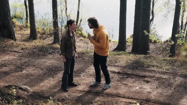 Två manliga vänner står på skogen gångstig och gräl på soliga dag — Stockvideo