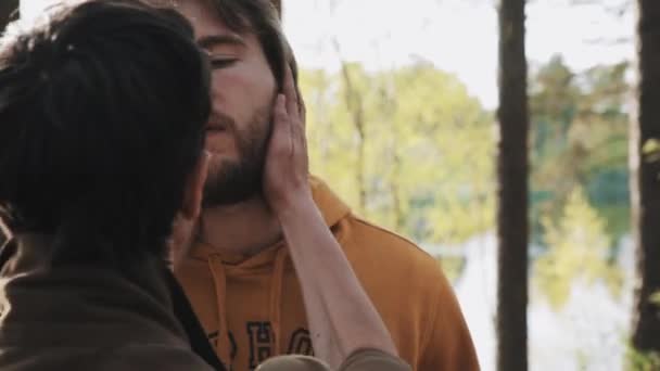 Vechtpartijen man houdt zijn vriend bebaarde gezicht terwijl ruzie in bos — Stockvideo