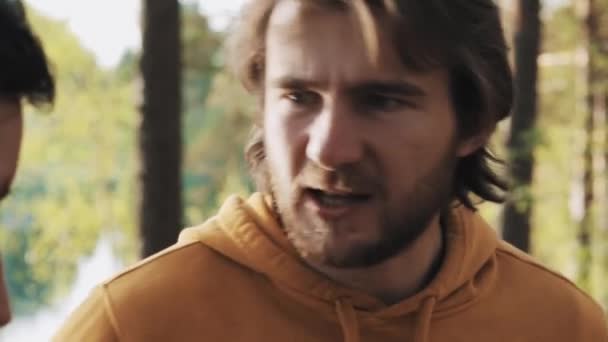 Cabello largo enojado hombre peleas con amigo en el bosque — Vídeos de Stock