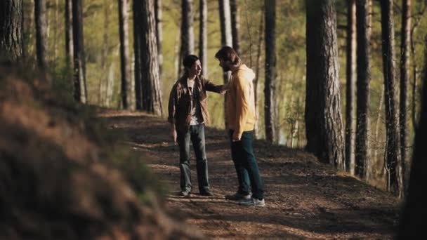 Man grijpt zijn bebaarde vriend schouder terwijl ruzie in bos — Stockvideo