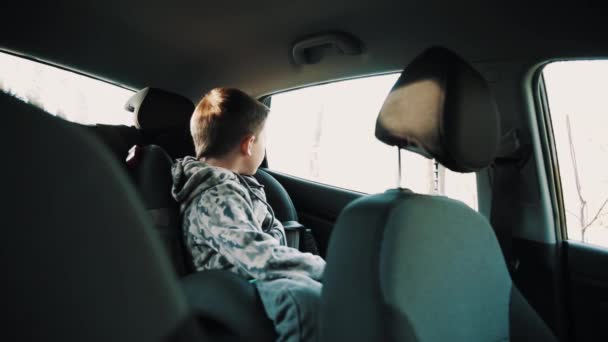 Little kid boy climbs out child chair in automobile — Stock Video