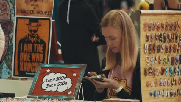 Saint Petersburg, Rusya - 20 Mayıs 2017: akıllı telefon kiosk kalabalık konveksiyon oturan swiping kız tüccar — Stok video