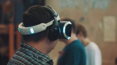 Saint Petersburg, Rusya - 20 Mayıs 2017: Adam shooter video oyun silah denetleyicisi kullanarak sanal gerçeklik kulaklık