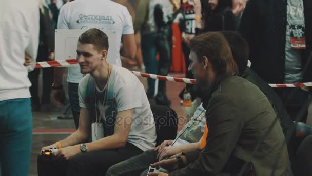 Санкт-Петербург, Російська Федерація - 20 травня 2017: Хлопці сидять на фестивалі грати у відеоігри, носіння шестигранним пазом — стокове відео