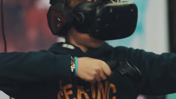 SAN PETERSBURG, RUSIA - 20 DE MAYO DE 2017: Niño en realidad virtual de la cabeza del engranaje jugando videojuego, hacer movimientos de tiro con arco — Vídeo de stock