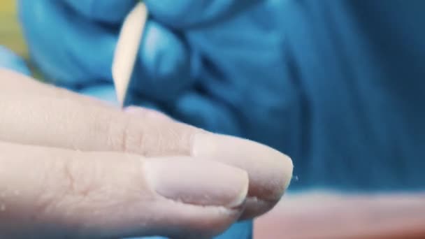 Рука маникюрши с помощью файла на ногтях клиента для полировки поверхности в салоне красоты — стоковое видео