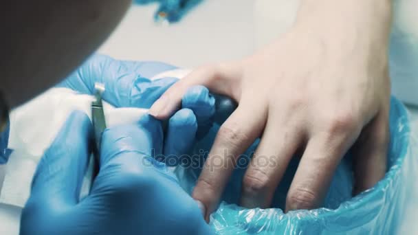 Kosmetička v salonu pomocí hřebíku kleště snížit kůžičky prsty klienta