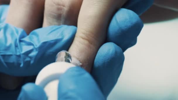 Cosméticien dans l'atelier de beauté en utilisant des pinces à ongles pour couper la cuticule des doigts du client — Video