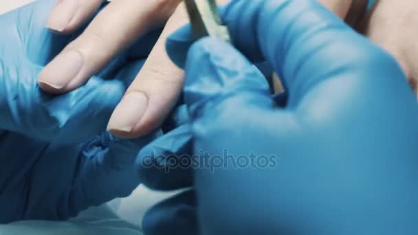 Manicure no salão de beleza usando pinças de unhas para cortar a cutícula dos dedos do cliente — Vídeo de Stock