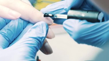 Makyajcısı el şeffaf oje istemci başparmak çivi üzerine salonda koyar.