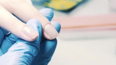 Manikürcü el şeffaf oje istemci başparmak çivi üzerine salonda koyar.