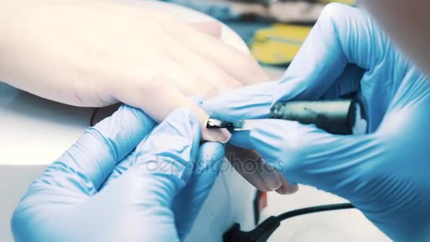 Main cosmétique met vernis à ongles clair sur l'ongle du pouce du client dans le salon — Video