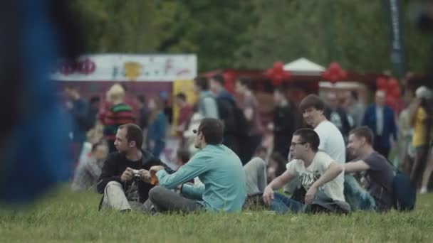 SAN PETERSBURG, RUSIA - 24 DE JUNIO DE 2017: Grupo de tíos frikis sentados en el césped en el festival de verano al aire libre — Vídeos de Stock