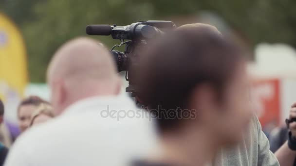 SAINT PETERSBURG, RÚSSIA - JUNHO 24, 2017: Jovem cameraman preocupado olha para o visor no evento ao ar livre de verão — Vídeo de Stock