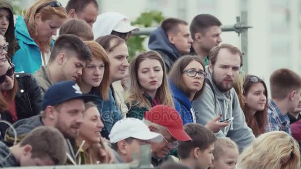СЕНТ-ПЕТЕРБУРГ, РОССИЯ - 24 июня 2017 года: Молодые люди сидят на местах на летнем фестивале под открытым небом — стоковое видео