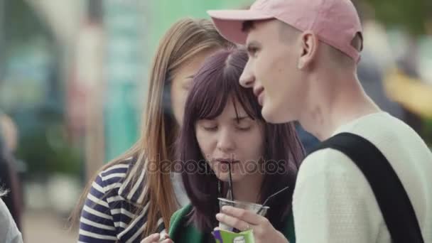 САЙНТ-ПЕТЕРБУРГ, РОССИЯ - 24 июня 2017 года: Группа подростков пьет молочный коктейль и курит на летнем фестивале под открытым небом — стоковое видео