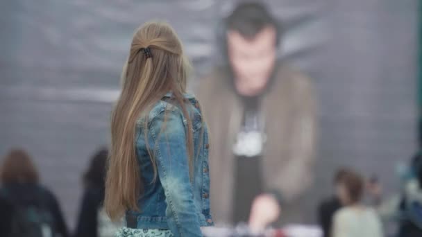 SAINT PETERSBURG, RÚSSIA - JUNHO 24, 2017: Jovem menina alegre acaricia o cabelo na frente de tela grande no festival de música — Vídeo de Stock