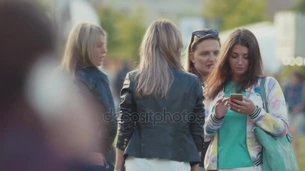 SAINT PETERSBURG, RÚSSIA - JUNHO 24, 2017: Grupo de meninas conversando e mensagens de texto em smartphones no parque da cidade lotada — Vídeo de Stock