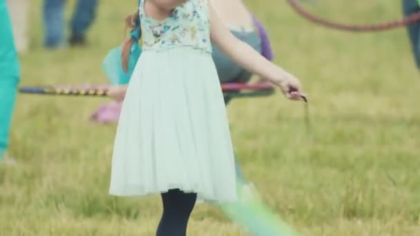 SAN PETERSBURG, RUSIA - 24 DE JUNIO DE 2017: Chica infeliz haciendo girar cintas voladoras en la hierba en el festival al aire libre de verano — Vídeo de stock
