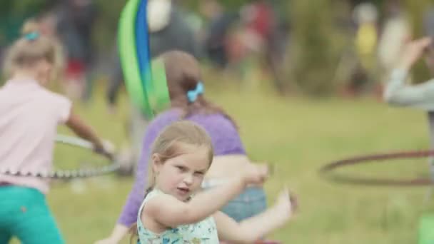 Санкт-Петербург, Російська Федерація - 24 червня 2017: Маленька дівчинка спінінг літаючих стрічками на траві на літніх відкритий фестиваль — стокове відео