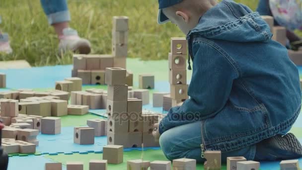 상트페테르부르크, 러시아-6 월 24 일, 2017: 작은 아이 나무 벽돌 및 대리석 공 야외 공원에서 놀고 — 비디오