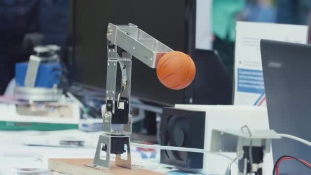 SAN PETERSBURG, RUSIA - 24 DE JUNIO DE 2017: Brazo robot mecanizado levantando una pequeña bola de canasta en la mesa del evento científico — Vídeos de Stock