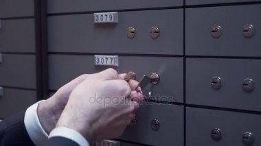 Banka yöneticisi el ile istemci yaşlı adam iki anahtar kullanarak güvenli hücre kadar kilitleme