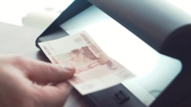 Geschäftsmann Hand überprüft Fünftausend-Rubel-Banknote auf weißem Licht — Stockvideo