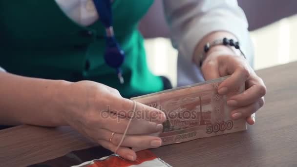 Gerente del banco mujer poner cinta alrededor de billetes de rublo dinero — Vídeo de stock