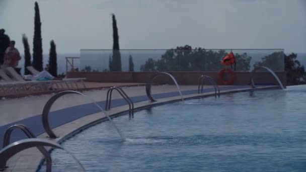 Luxe resort zwembad met metalen watervallen — Stockvideo