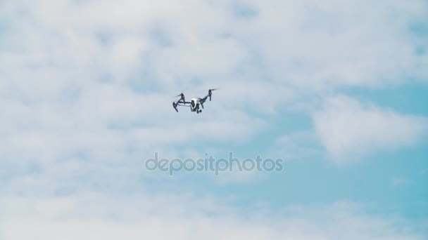 Filmación de quadrocopter volando frente a nubes blancas del cielo azul — Vídeos de Stock