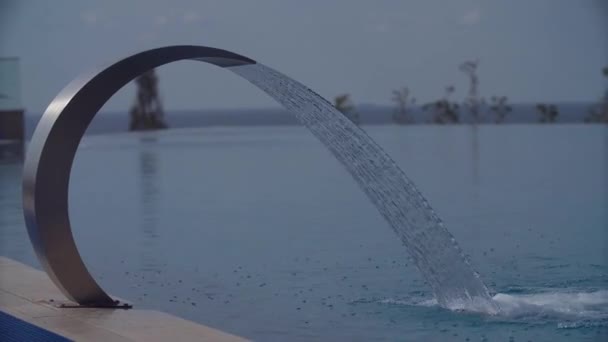 Бассейн водопад льет воду в курортной зоне в солнечный летний день — стоковое видео