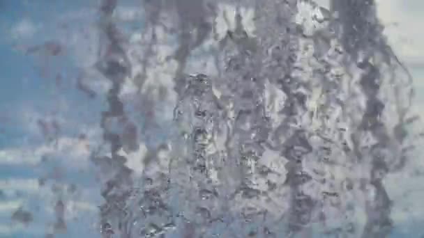 Jatos de fonte de água salpicos na frente do céu azul nublado — Vídeo de Stock