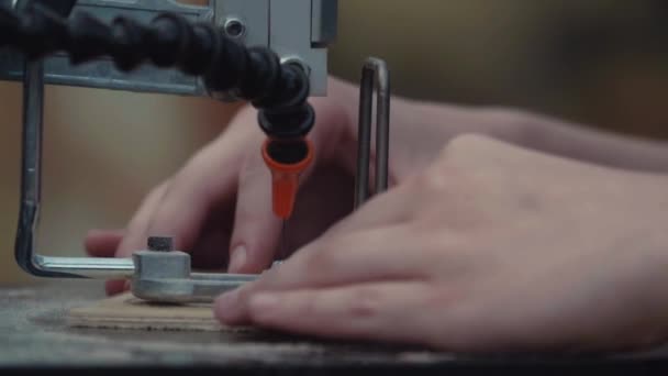 Slow motion woodworker händer skära mönster ut högen trä på jiggen såg maskinen — Stockvideo
