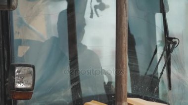 Otururken Ekskavatör sürücü koyu camlı kabin, slowmotion. Mavi gökyüzü