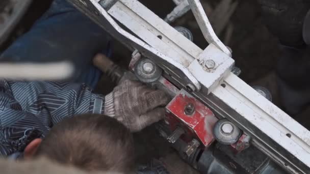 Dos hombres recogiendo grandes taladros industriales en una zanja sucia con llave inglesa. Lento. — Vídeos de Stock