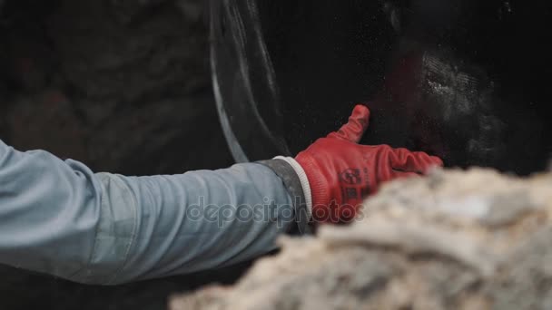 Trabajador en guantes de goma roja sostienen anillo de alcantarilla de hormigón colocando en a zanja — Vídeos de Stock