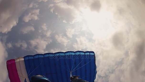 Прыгун в шлеме с парашютом в облачном небе. Приземление. Экстремальный спорт. Баланс . — стоковое видео