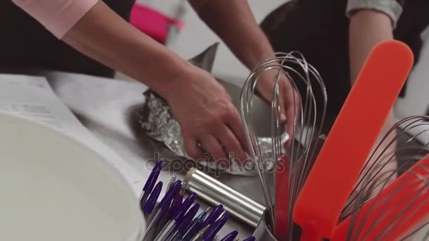 Mujer pastelera manos del chef envuelve bandeja para hornear en papel de aluminio en la cocina — Vídeo de stock