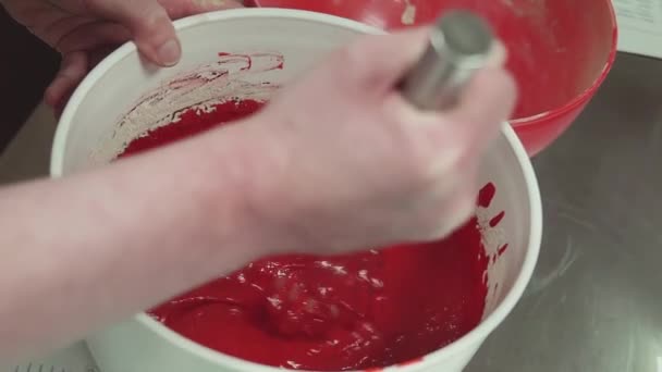 Pâtisserie féminine cuire les mains mélangeant la pâte de couleur rouge à l'aide de fouet — Video