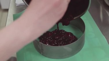 Yemek mutfak spatula kullanarak yedekleme içine simmered çilek pasta şefi koyar