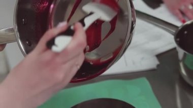 Pudra simmered çilek yemek mutfak spatula kullanarak yedekleme içine koyar