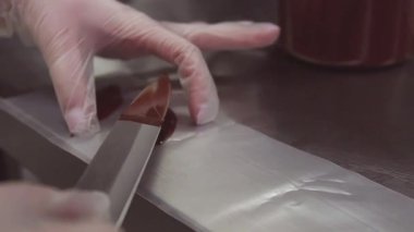 Plastik eldiven elinde kadın pudra şerit yemek çikolata koyar