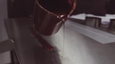 Eritilmiş çikolata plastik şeritler üzerinde fincan ölçme döküntüler