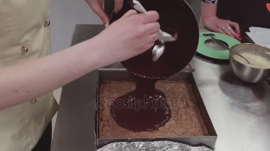 Bisküvi pişirme tepsisi içinde üzerinde eritilmiş çikolata pasta şefi dökülen