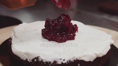 Berry reçel kaşığı çırpılmış krem kısa çikolatalı kek bisküvi üzerine koyar