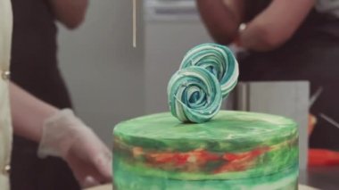 Pasta şefi ellerini süsleyen lolipop ile renkli kek