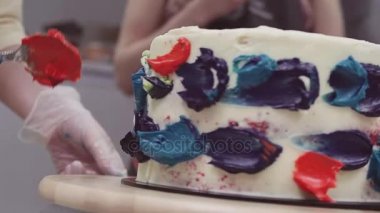 Pasta şefi ellerini koyar kaşıkla sünger kek üzerine krema renkli krem