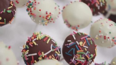 Tatlı topları çikolata sosu ile renkli confetty ile dekore edilmiştir.
