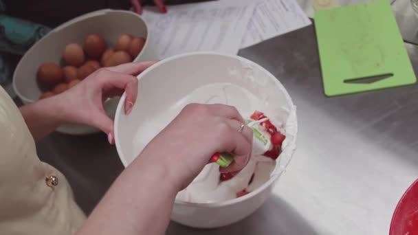 Pastelera femenina mezclando fresa cortada con crema batida en la cocina — Vídeo de stock